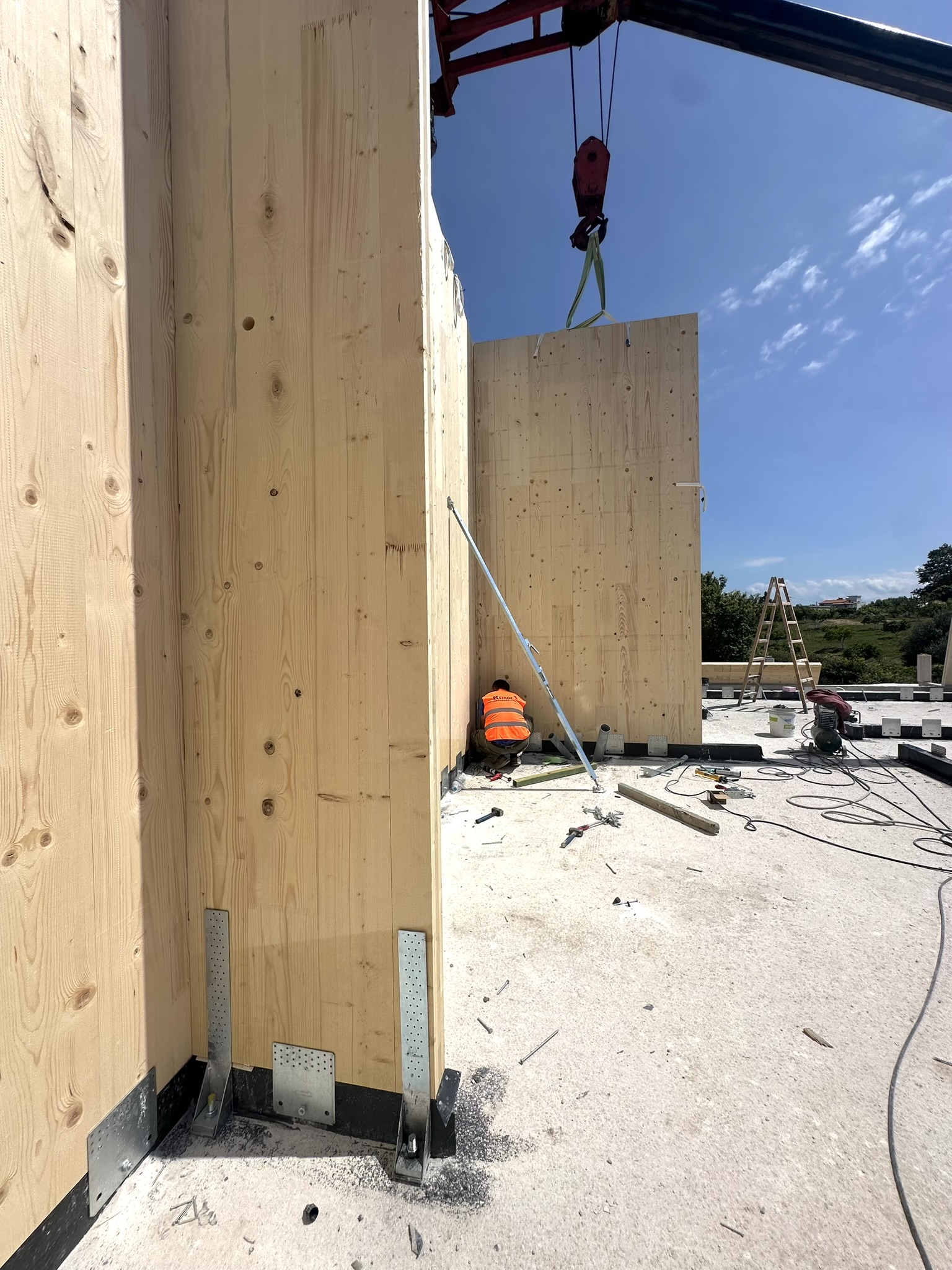 Γερανός ανυψώνει κατακόρυφο CLT τοίχο: φαίνεται η μάζα και το μέγεθος του panel